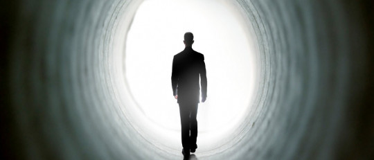 Hombre caminando hacia la luz.