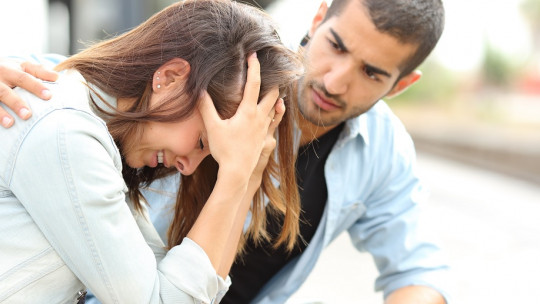 Hombre consolando a una mujer que llora.