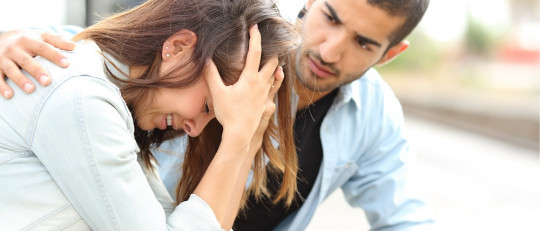 Hombre consolando a una mujer que llora.