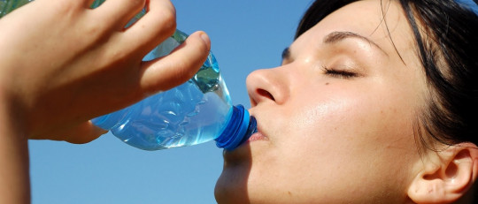 Mujer bebiendo agua.