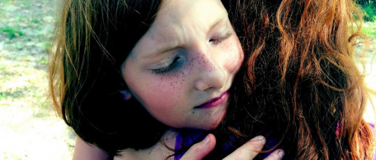 Niña abrazando a mujer.