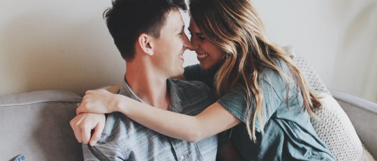 Pareja abrazándose en el bosque.