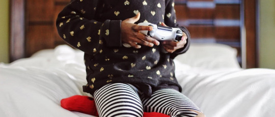 Niña pequeña jugando con una videoconsola.