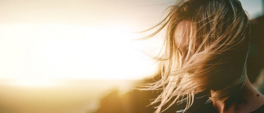 Mujer frente a una puesta de Sol.