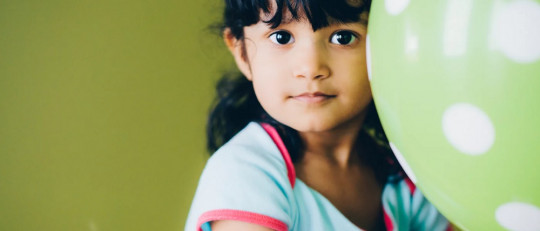 Niña jugando con un globo.