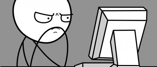 Hombre serio frente al ordenador.