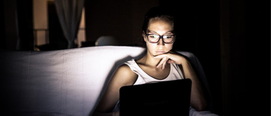 Mujer usando un ordenador portátil.