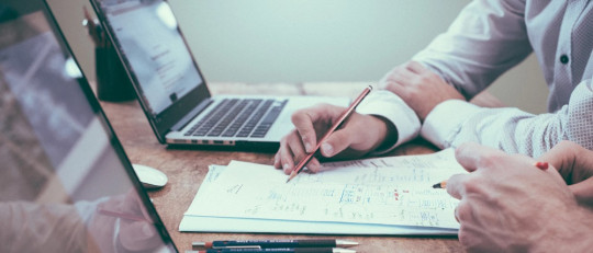 Hombres trabajando con ordenadores portátiles.