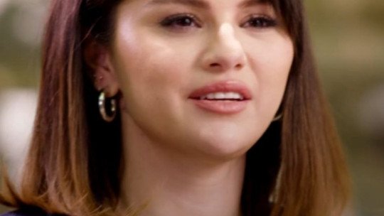 Selena Gomez, con el pelo castaño a la altura de los hombros y chaqueta oscura, habla durante una conversación sobre salud mental en la Casa Blanca en 2022