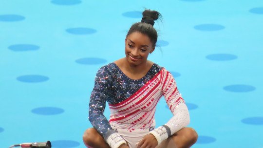 Simone Biles, sentada con las piernas cruzadas sobre el tapiz, durante los Juegos Olímpicos de París 2024
