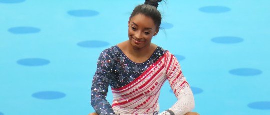 Simone Biles, sentada con las piernas cruzadas sobre el tapiz, durante los Juegos Olímpicos de París 2024