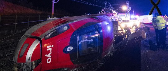 Tren descarrilado en el accidente ferroviario de Adamuz, de noche, con lazo negro de luto